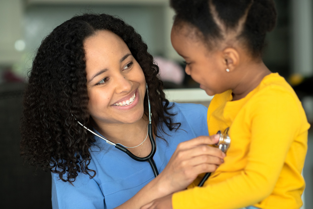 Female healthcare worker providers care to a young girl. Female healthcare worker providers care to a young girl.