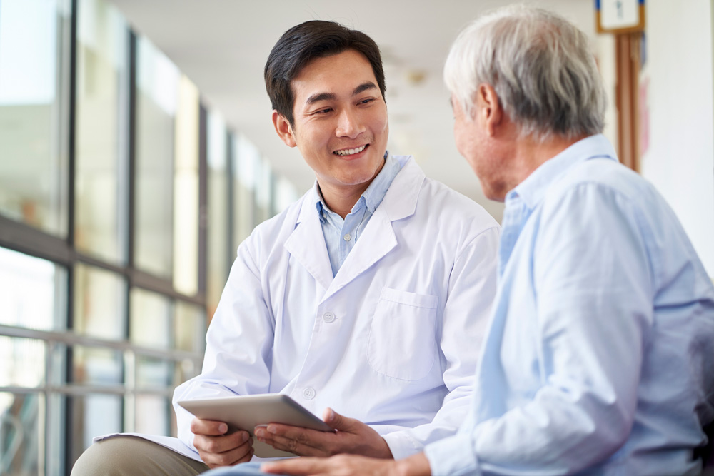 Asian doctor with elderly patient.