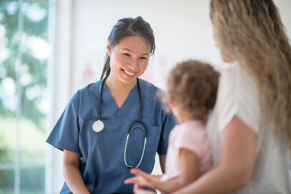 Asian nurse with mom and baby.