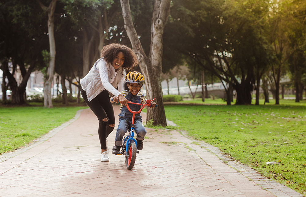 Mom teaching the son how to ride a bike. Mom teaching the son how to ride a bike.
